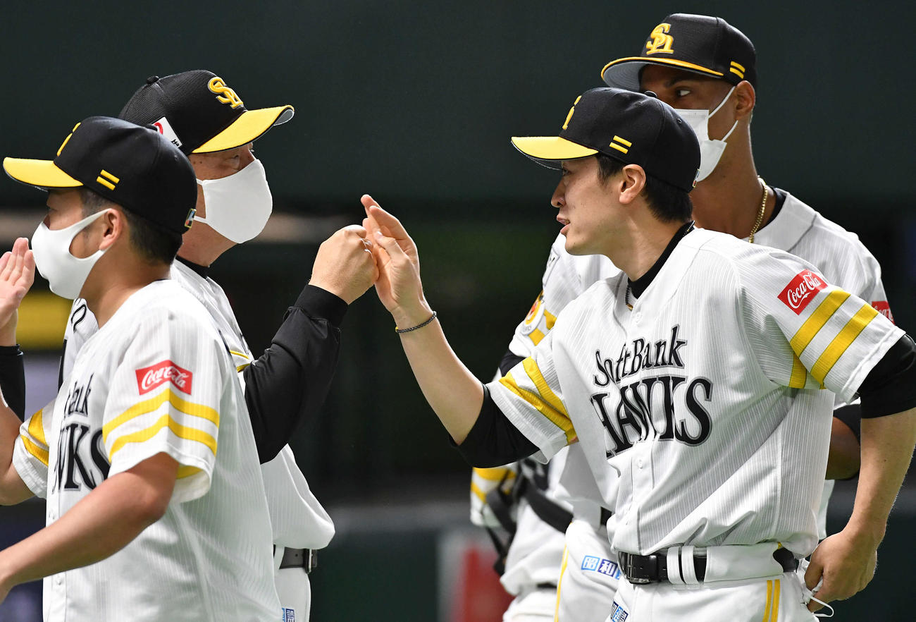 ソフトバンク対楽天　日米通算150勝を達成した和田（右手前）は藤本監督とタッチを交わす（撮影・岩下翔太）
