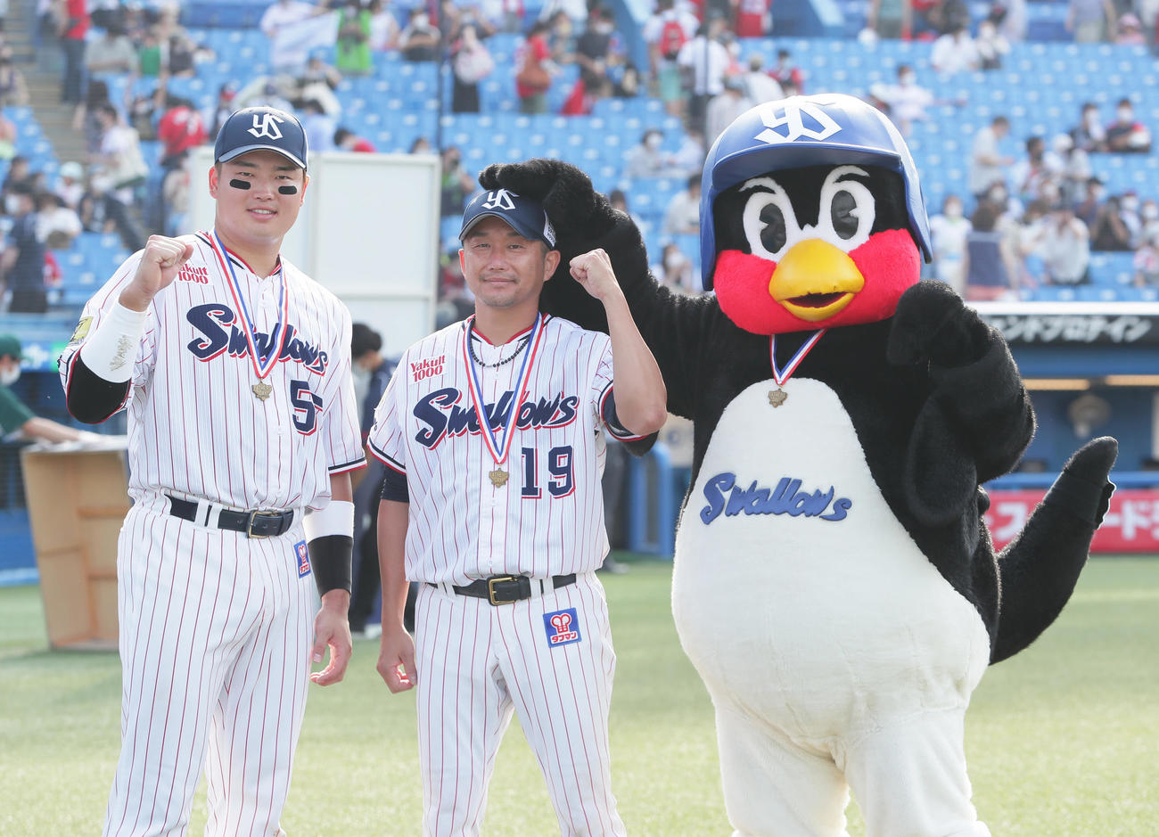 4勝目を挙げたヤクルト石川（中央）はつば九郎から頭をなでられる。左は村上（撮影・足立雅史）