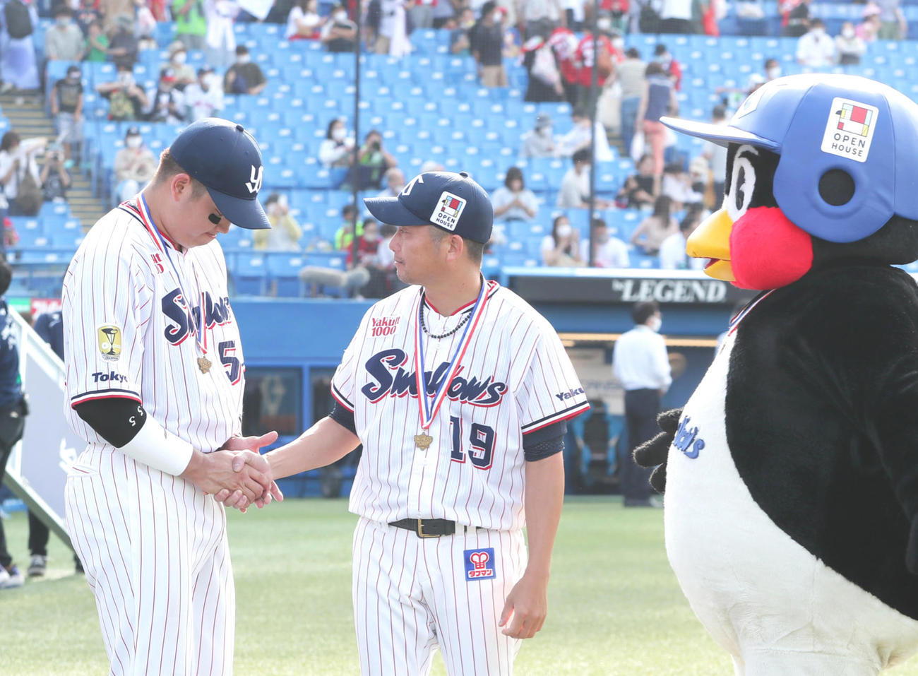 7回3失点で4勝目を挙げたヤクルト石川（中央）は2本塁打の村上と握手を交わす。右はつば九郎（撮影・足立雅史）