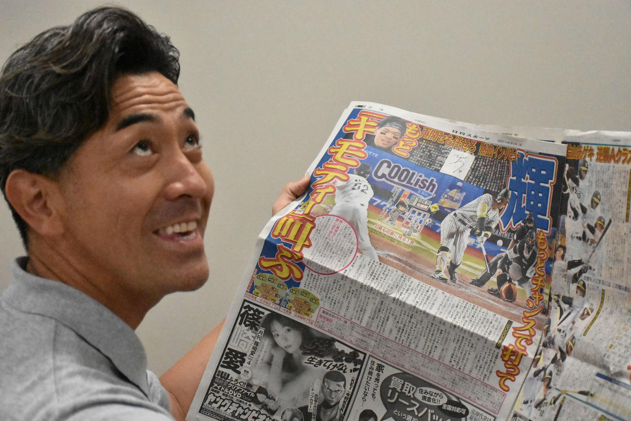 日刊スポー本紙に躍る「キモティー」の見出しを確認し、ビックリするG・G・佐藤氏（撮影・真柴健）