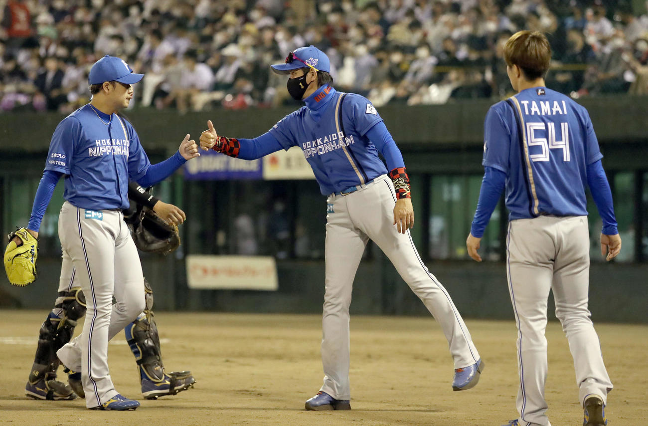 7回裏を無失点に抑えた堀（左）を出迎える新庄監督（撮影・佐藤翔太）