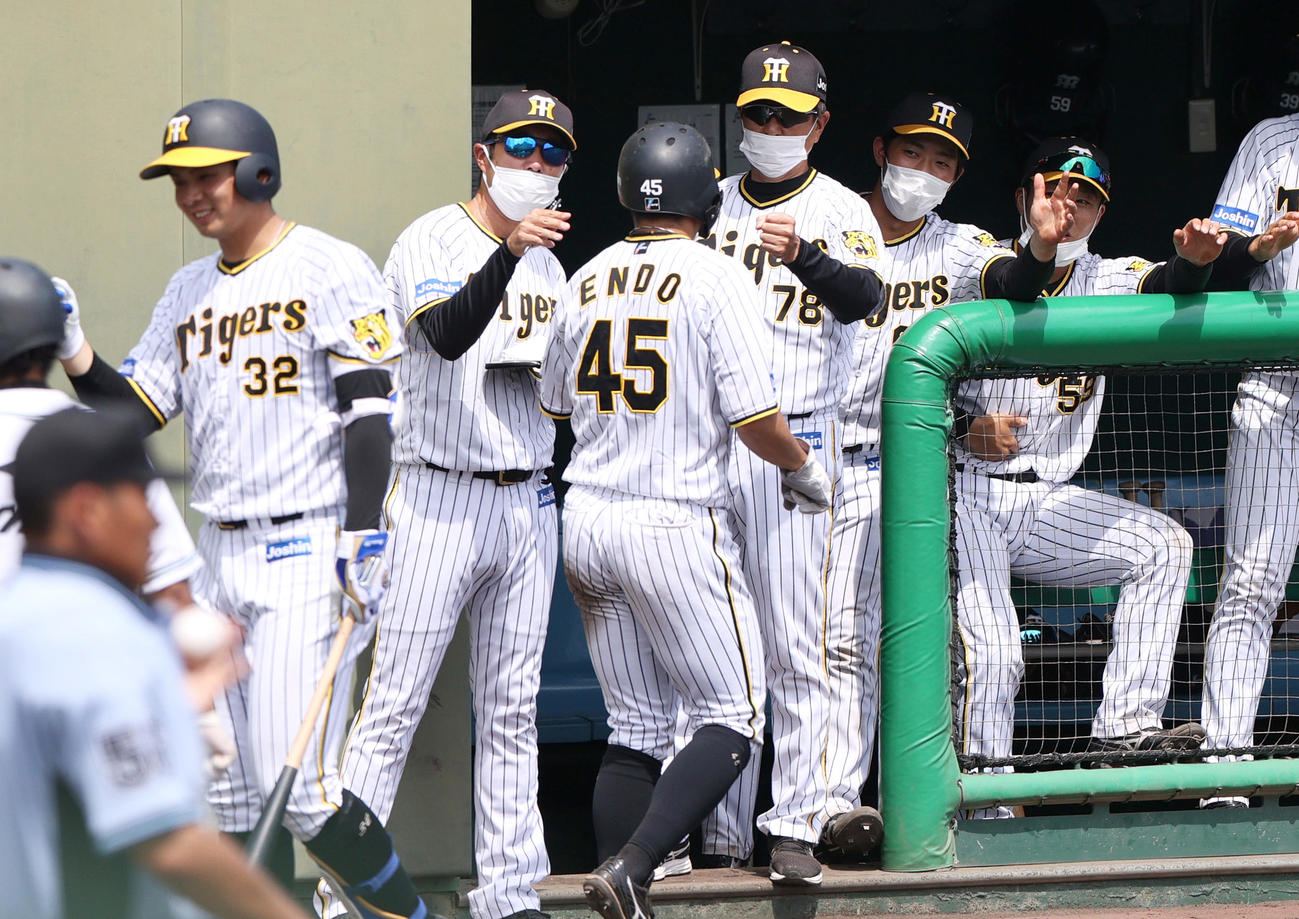 阪神対広島　4回裏阪神2死一、二塁、平田2軍監督（右から3人目）は小幡の中適時2点二塁打で生還の遠藤（手前右）を出迎える（撮影・上山淳一）