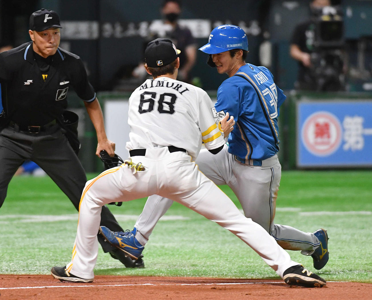 ソフトバンク対日本ハム　1回表日本ハム2死一、三塁、本盗を狙うも三本間に挟まれてタッチアウトとなった石井（右）、左は三森（撮影・岩下翔太）
