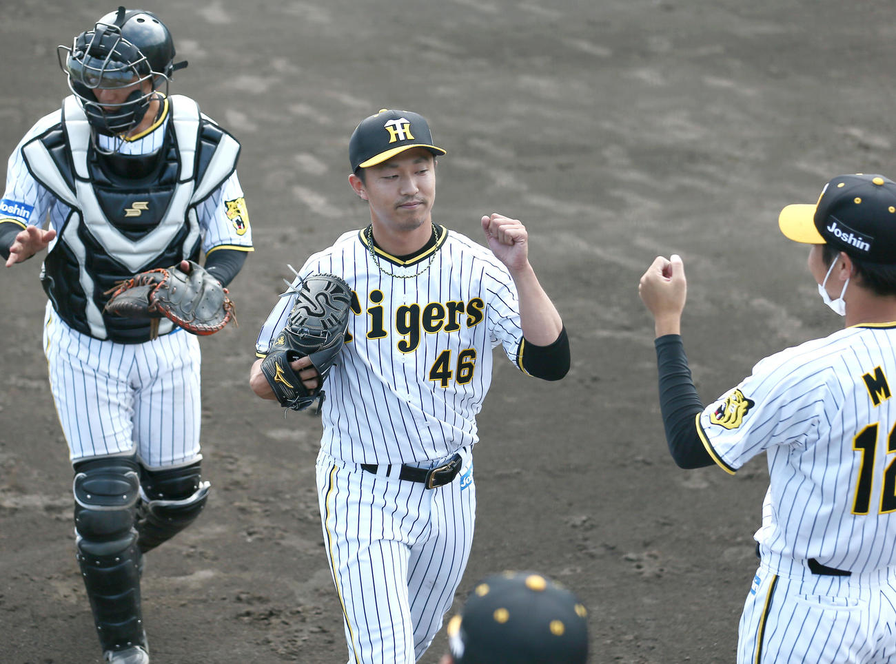 阪神対広島　8回に登板した阪神島本（中央）は3者凡退に抑えナインの出迎えを受ける（撮影・上山淳一）