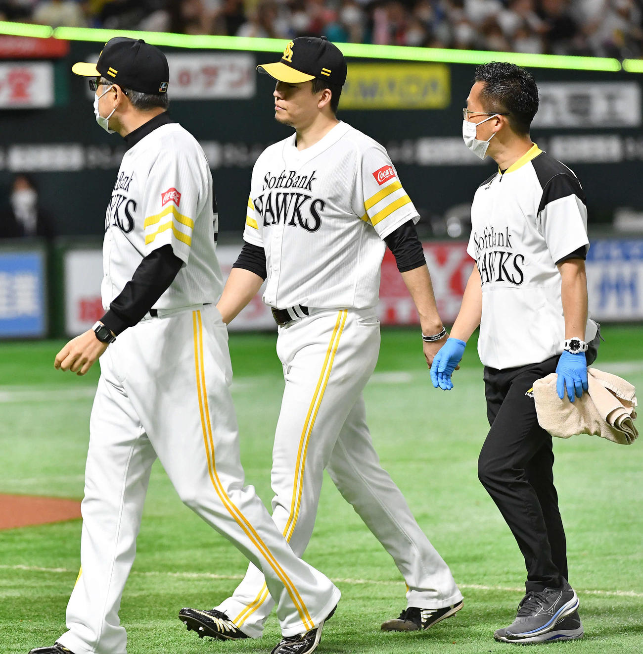 ソフトバンク対日本ハム　6回表の投球練習中に違和感を訴え、森山コーチ（左）とベンチへ戻る千賀（撮影・岩下翔太）