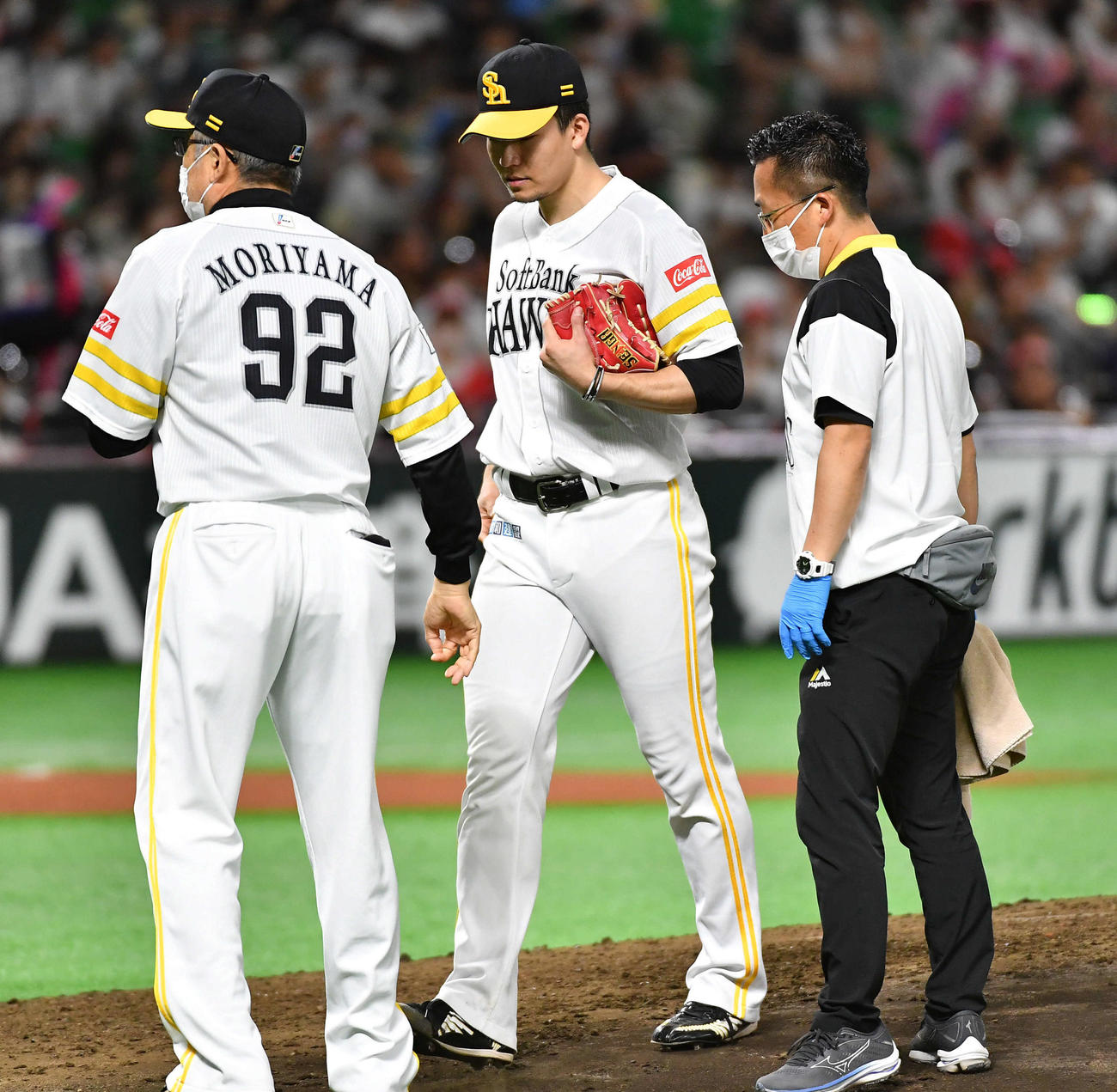 ソフトバンク対日本ハム　6回表の投球練習中に違和感を訴え、森山コーチ（左）とベンチへ戻る千賀（撮影・岩下翔太）