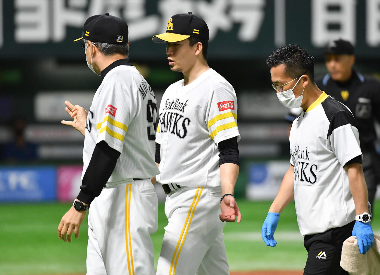 ソフトバンク対日本ハム　6回表の投球練習中に違和感を訴え、森山コーチ（左）と話しながらベンチへ戻る千賀（撮影・岩下翔太）