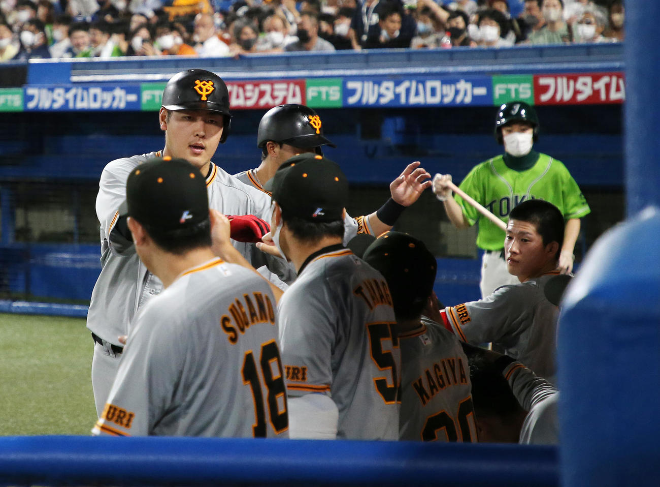 ヤクルト対巨人　9回表巨人無死1塁、岡本和（左）は中越え2点本塁打を放ちベンチ前でタッチ（撮影・鈴木正人）