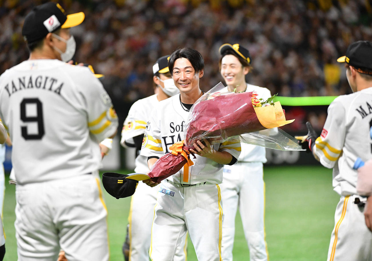 ソフトバンク対日本ハム　公式戦通算1000試合出場を達成し、花束を手に笑顔を見せる明石（撮影・岩下翔太）