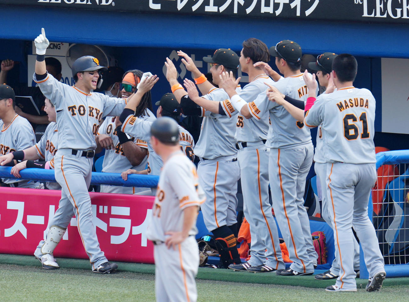 ヤクルト対巨人　7回表巨人2死二塁、左中間へ2点本塁打を放ちナインとタッチを交わす湯浅（左）（撮影・横山健太）