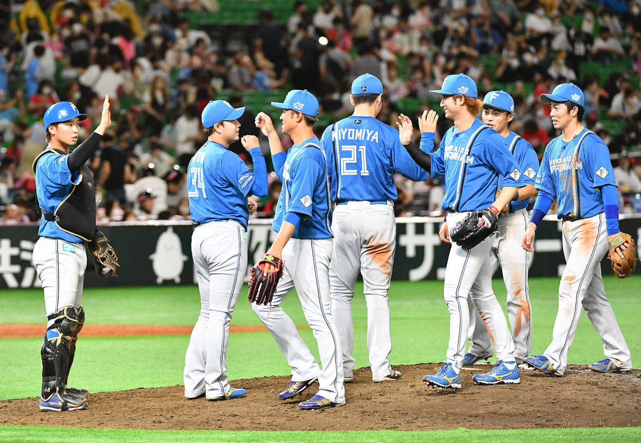 ソフトバンク対日本ハム　連敗を7で止め、笑顔でタッチを交わす日本ハムナイン（撮影・岩下翔太）
