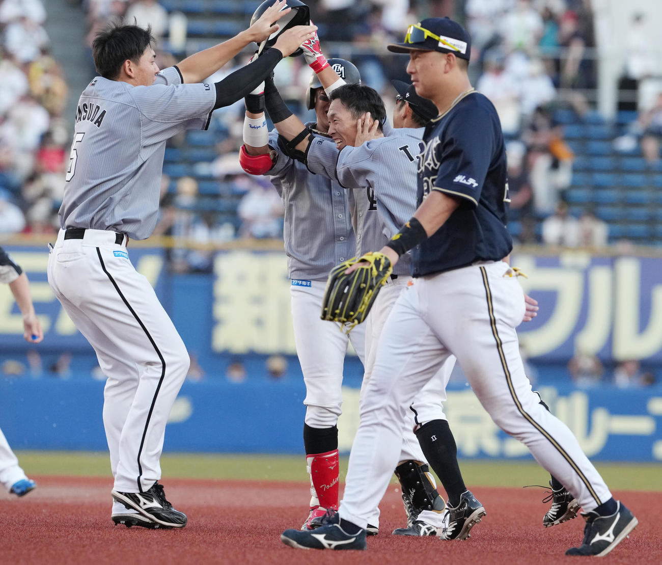 ロッテ対オリックス　11回裏ロッテ2死二塁、サヨナラ打を放った高部（中央）はナインから祝福を受ける。右は杉本（撮影・鈴木みどり）