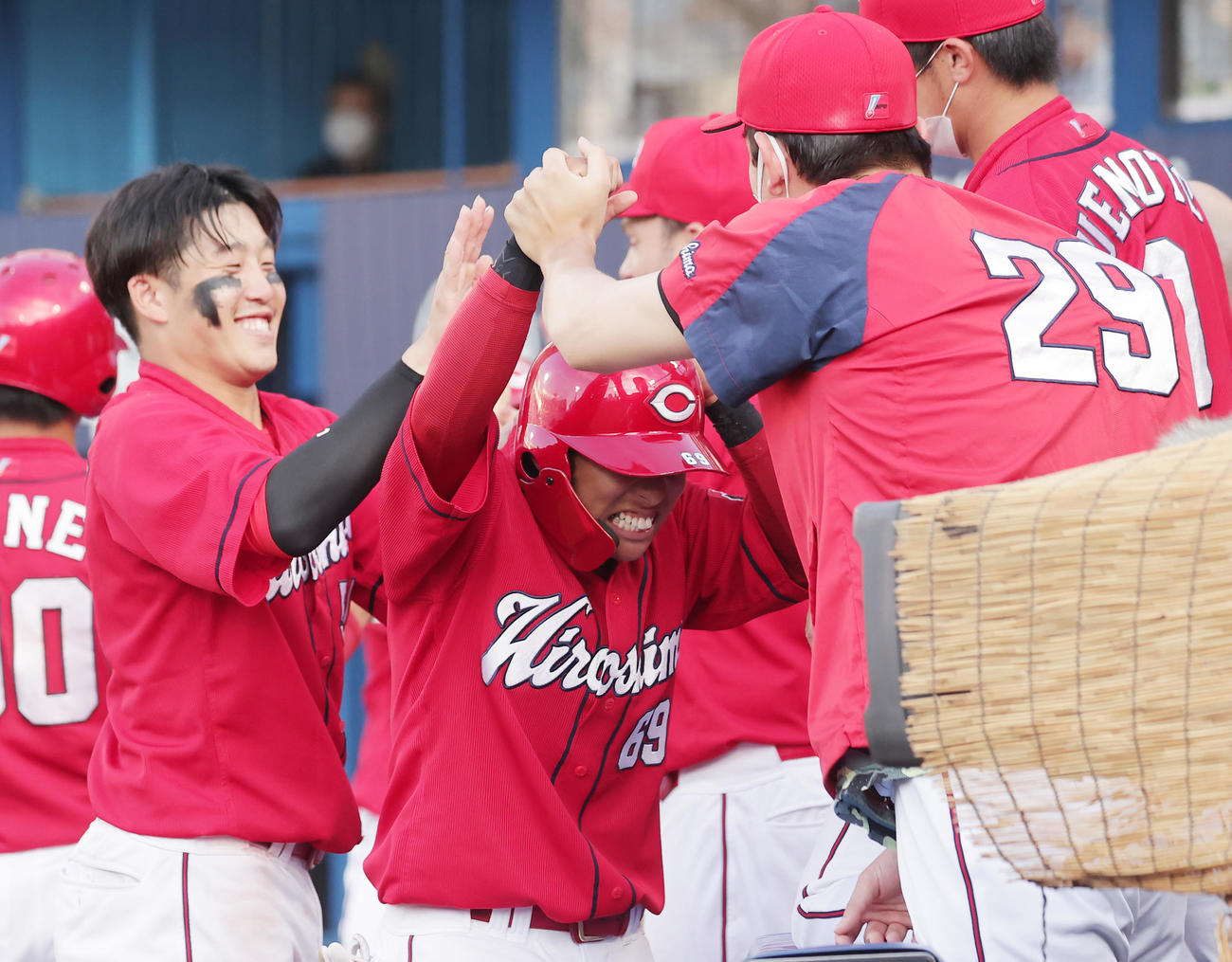 DeNA対広島　12回表広島1死三塁、松山の中犠飛で生還しベンチに迎えられる羽月（撮影・野上伸悟）
