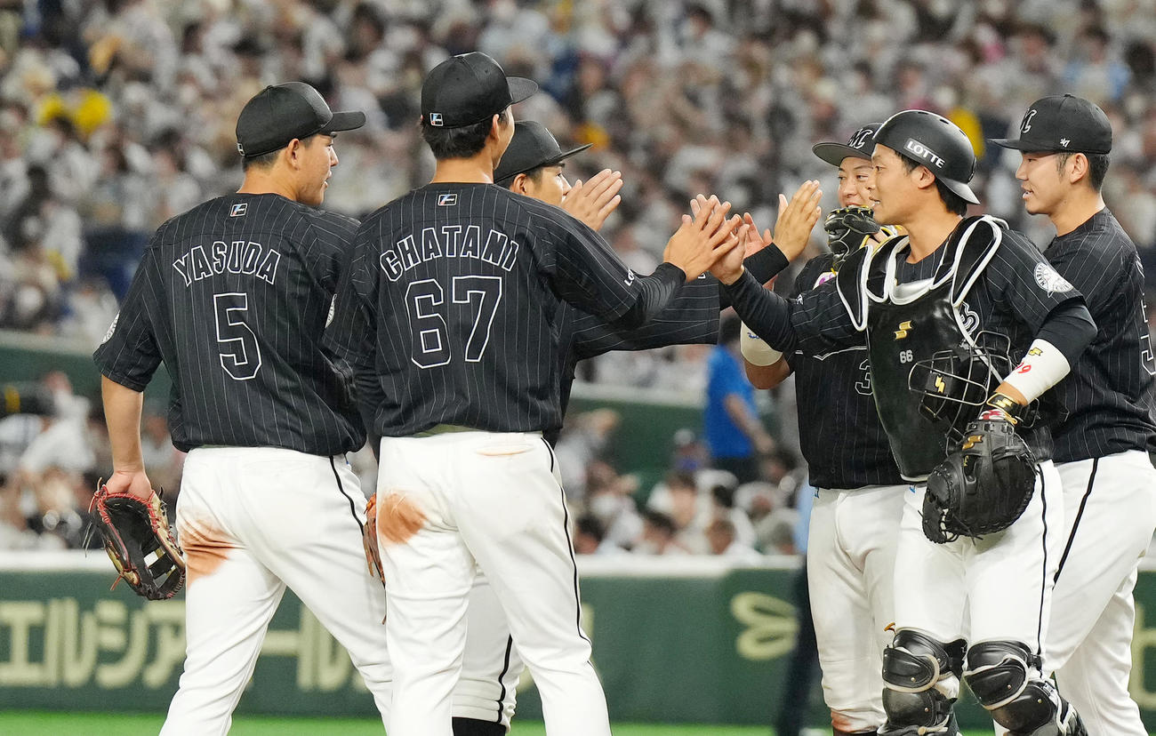 ソフトバンクに勝利し、ナインとタッチをするロッテ安田（左端）（撮影・菅敏）
