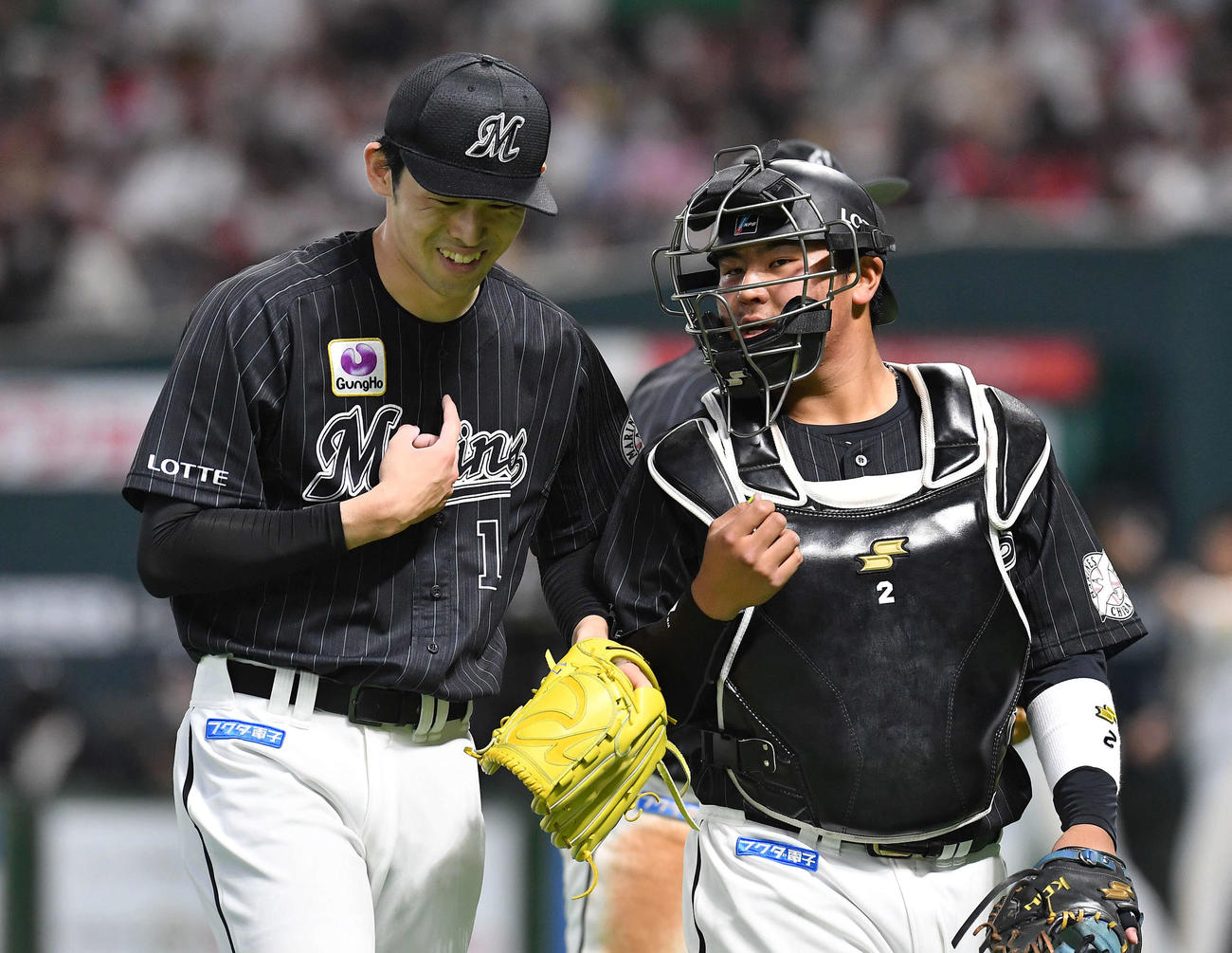 ロッテ松川虎生（右）と笑顔で話しながらベンチへ戻る佐々木朗希（2022年5月20日撮影）
