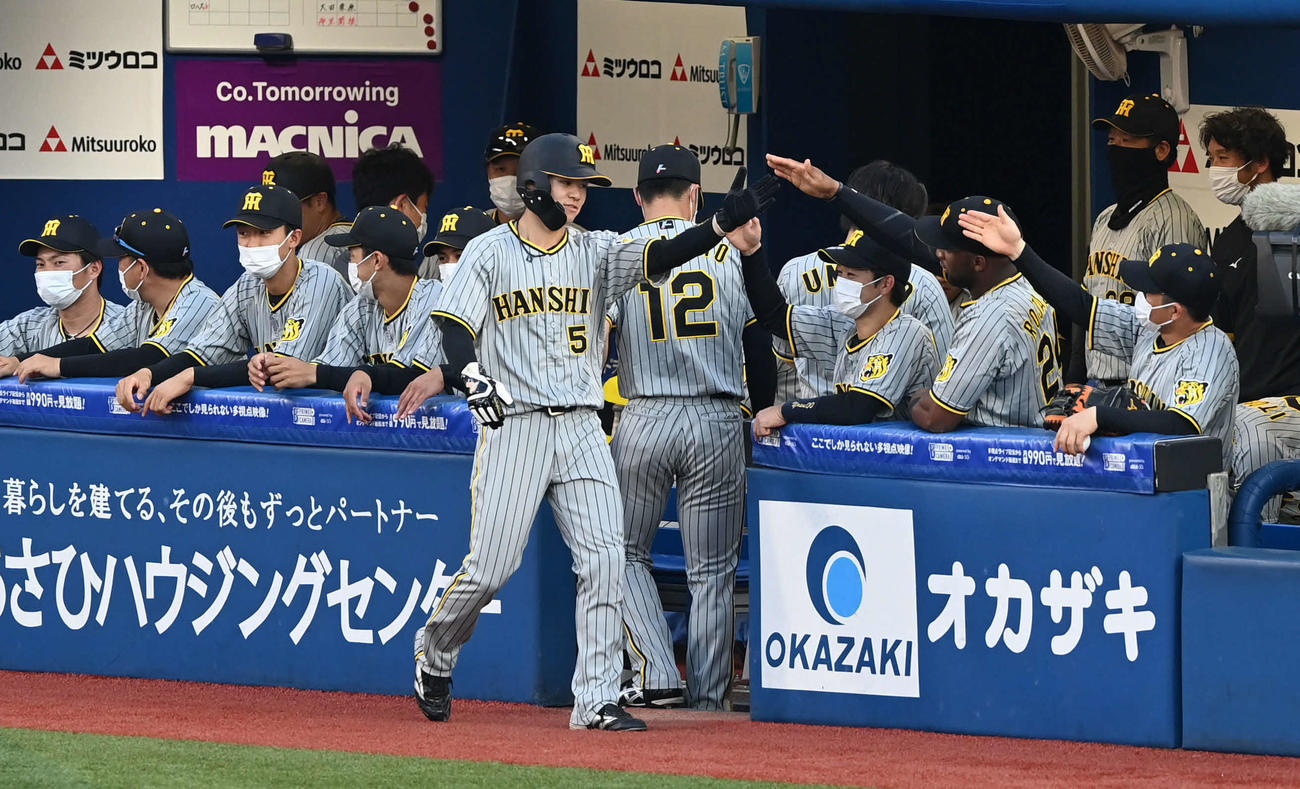 DeNA対阪神　1回表阪神無死二塁、島田の適時打で生還した中野（中央）はチームメートとタッチをかわす（撮影・山崎安昭）
