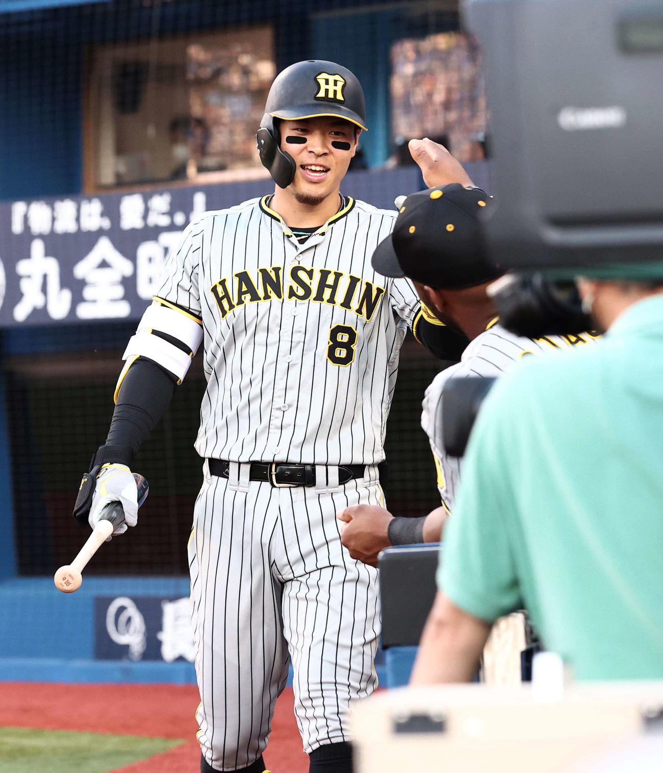 DeNA対阪神　1回表阪神1死三塁、中犠飛で打点をあげた佐藤輝は笑顔を見せながらナインとハイタッチする（撮影・上田博志）