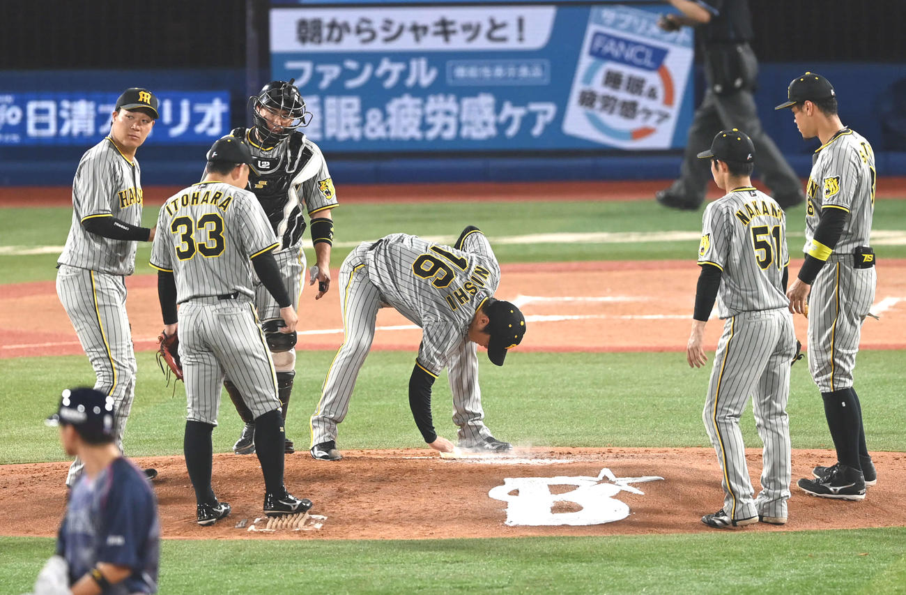 6回途中、降板する阪神西勇輝（右から3人目）はロジンでプレートをきれいにする（撮影・山崎安昭）