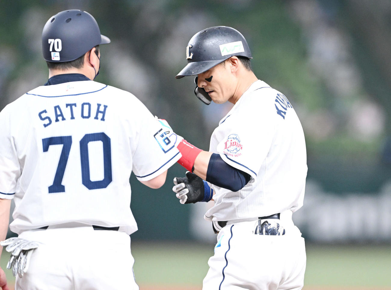 西武対日本ハム　1回裏西武2死三塁、右前適時打を放った栗山（右）は佐藤コーチとタッチを交わす（撮影・滝沢徹郎）