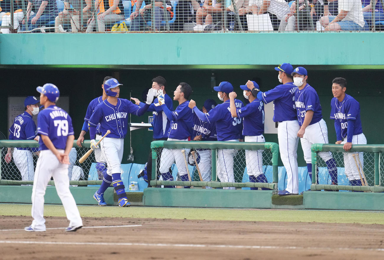 巨人対中日　3回表中日無死、右越えにソロ本塁打を放ち、ナインにタッチで迎えられる京田（左から3人目）（撮影・菅敏）