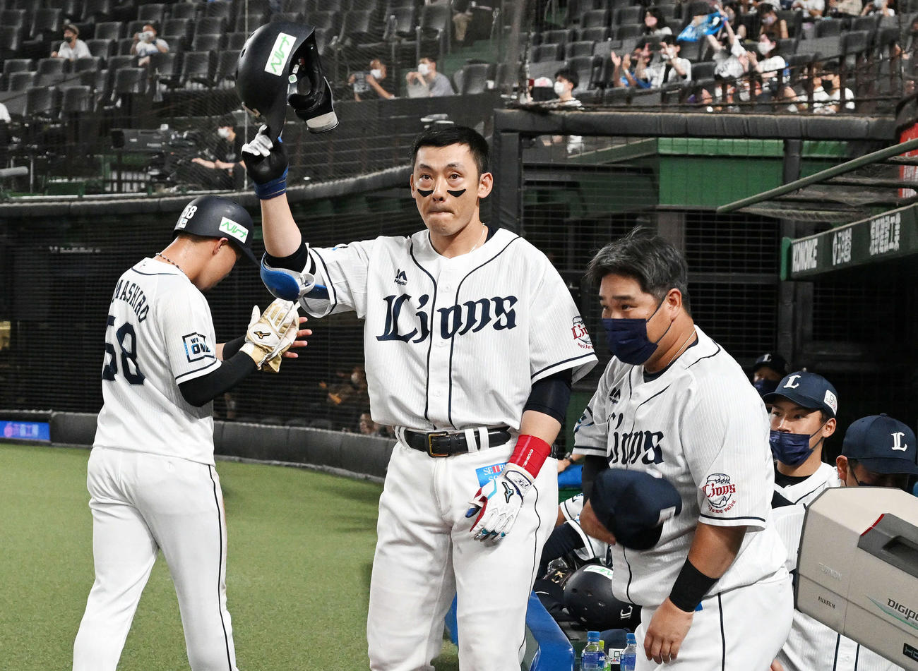 西武対日本ハム　8回裏西武1死一塁、同一球場1000安打となる右越え2点本塁打を放った栗山（中央）は生還しファンにあいさつする。右手前は中村（撮影・滝沢徹郎）