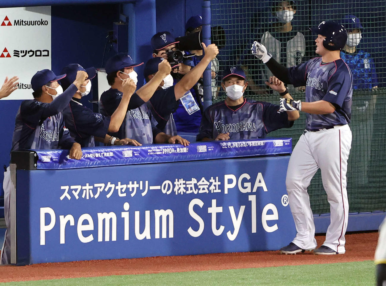 DeNA対阪神　4回裏DeNA無死満塁、ソトの勝ち越しの中犠飛で生還した牧（右）は石井コーチ（右から2人目）らとハイタッチ（撮影・浅見桂子）