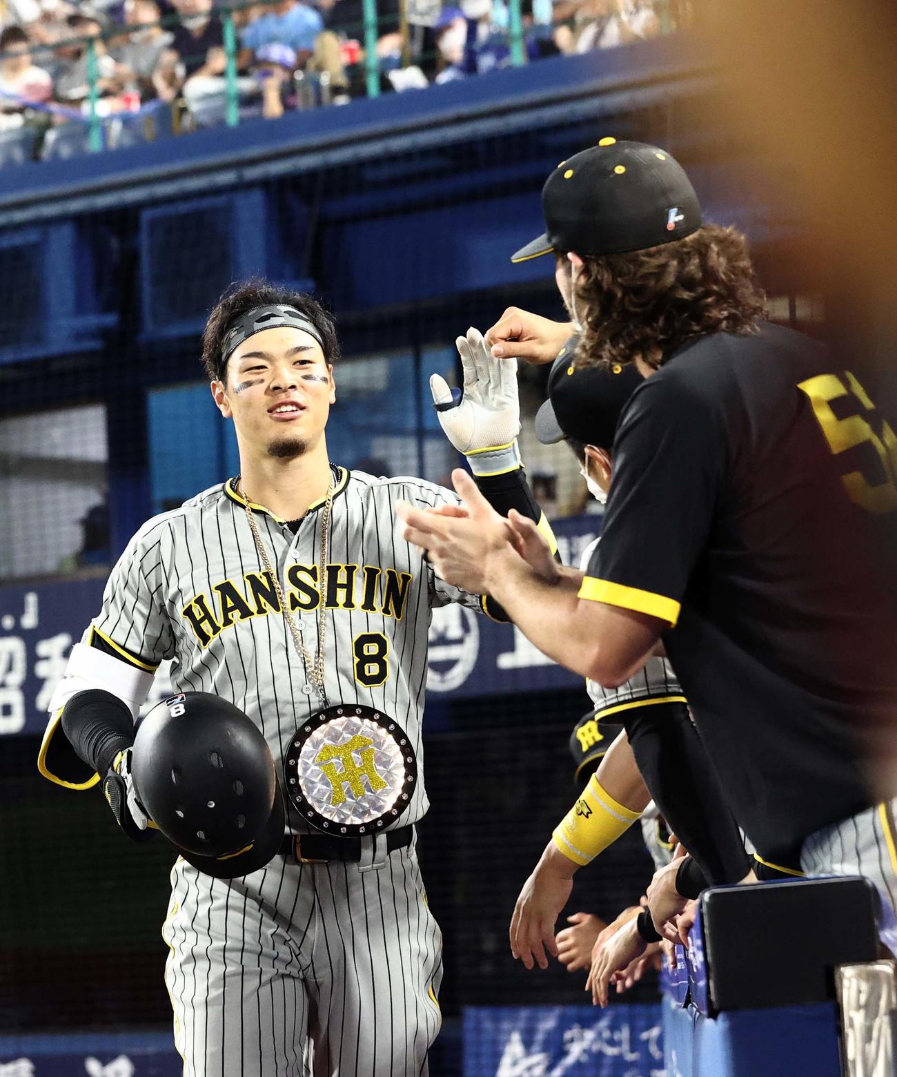 DeNA対阪神　7回表阪神2死、右越え同点本塁打を放った佐藤輝はナインの出迎えに笑顔を見せる（撮影・上田博志）