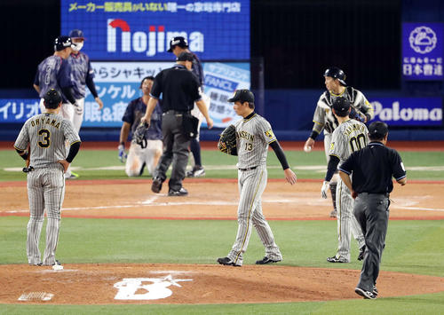 DeNA対阪神　9回裏DeNA2死一、二塁、嶺井のサヨナラ適時打での本塁生還のアウトセーフのリプレイ検証を、厳しい表情で待つ岩崎優（中央）ら阪神の選手たち（撮影・浅見桂子）