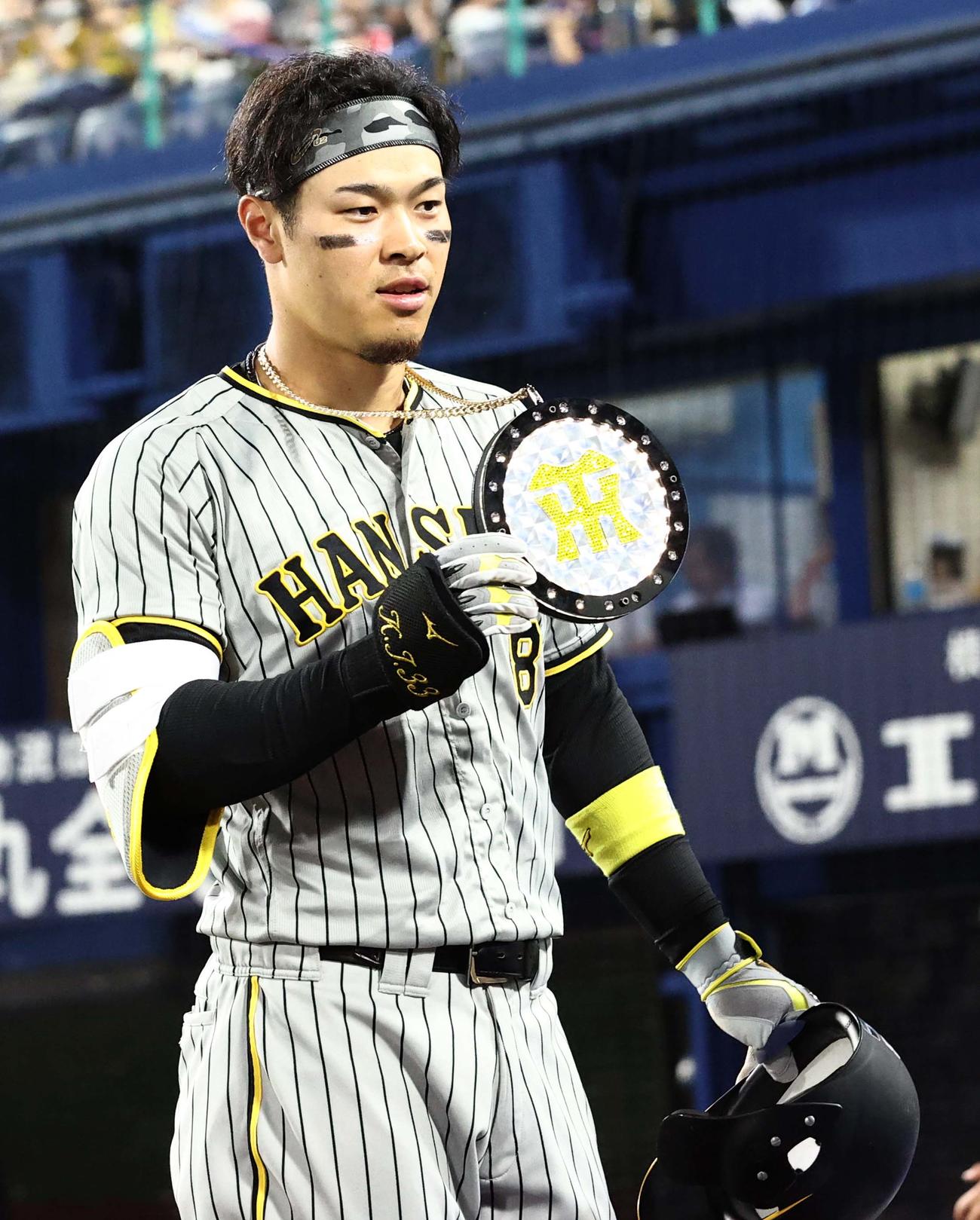 DeNA対阪神　7回表阪神2死、右越え同点本塁打を放った佐藤輝は本塁打メダルを掲げる（撮影・上田博志）