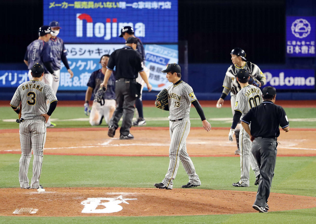 DeNA対阪神　9回裏DeNA2死一、二塁、嶺井のサヨナラ適時打での本塁生還のアウトセーフのリプレイ検証を、厳しい表情で待つ岩崎優（中央）ら阪神の選手たち（撮影・浅見桂子）