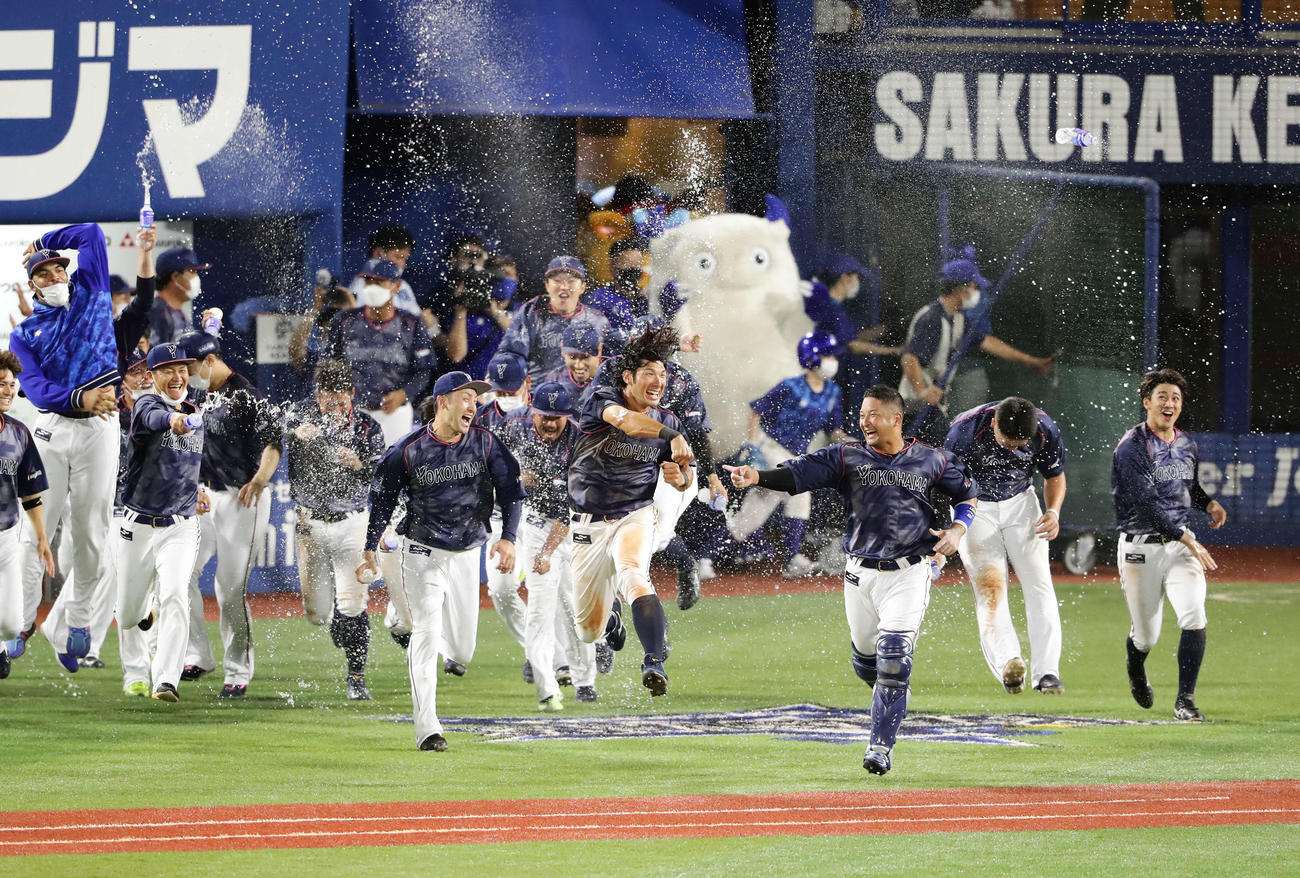 DeNA対阪神　9回裏DeNA2死一、二塁、嶺井（手前右）の右前打でサヨナラの生還をした大田（中央）は水シャワーで祝福され大喜びする（撮影・浅見桂子）