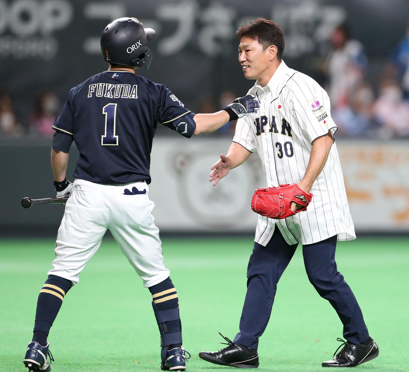 日本ハム対オリックス　オリックス福田（左）に謝る始球式を務めたU－12野球日本代表井端監督（撮影・佐藤翔太）