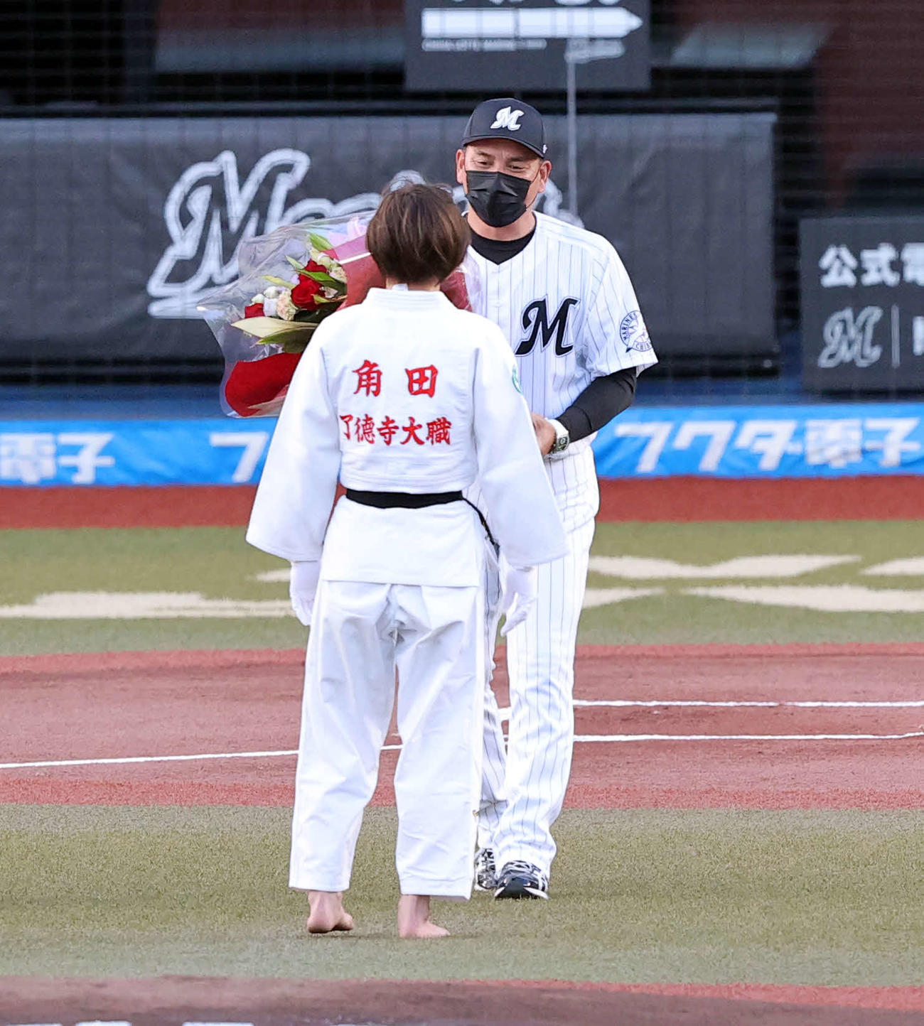 ロッテ対楽天　試合前のファーストピッチセレモニーに登場した柔道日本代表の角田夏実（手前）に花束を渡すロッテ井口監督（撮影・浅見桂子）