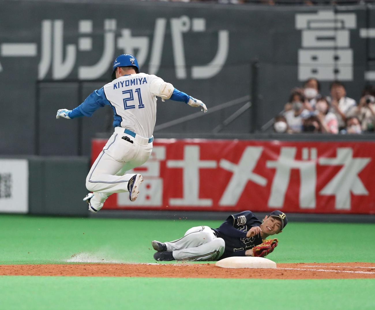 日本ハム対オリックス　4回裏日本ハム2死三塁、ニゴロを打った清宮（左）は一塁ベースカバーで転倒した山岡を飛び越える（撮影・黒川智章）