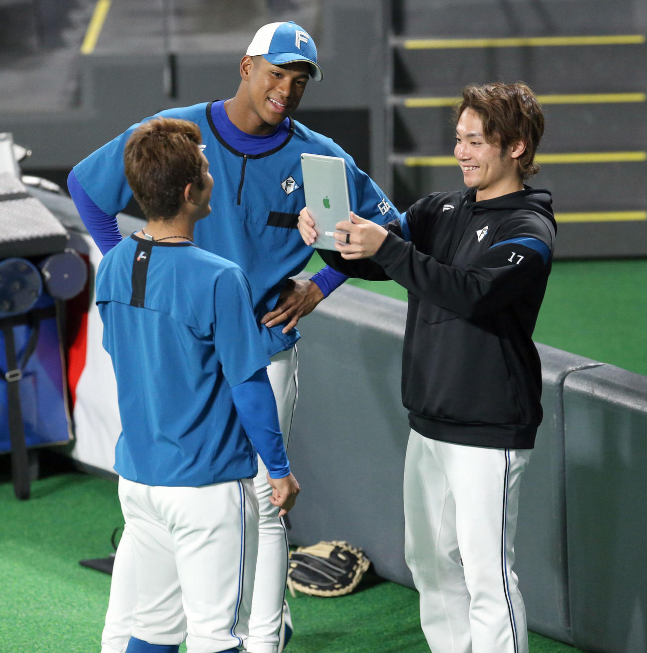 日本ハム今川（左手前）の顔を撮影する伊藤。左後方は万波（撮影・佐藤翔太）