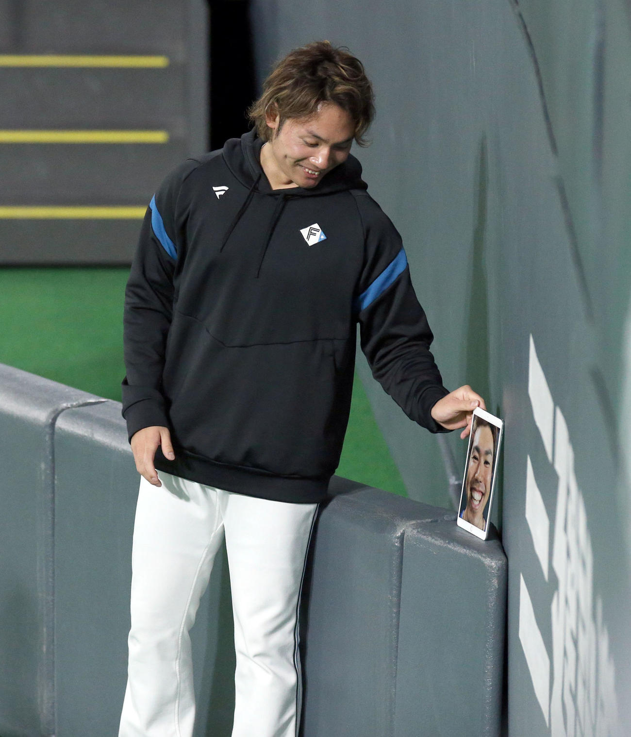 日本ハム今川の顔を撮影し壁に立て掛ける伊藤（撮影・佐藤翔太）