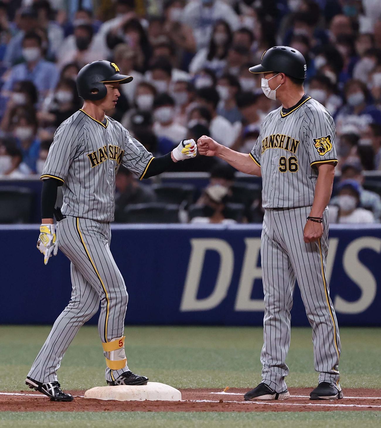 中日対阪神　3回表阪神2死一塁、近本（左）は左前安打を放ち筒井コーチとグータッチする（撮影・上田博志）