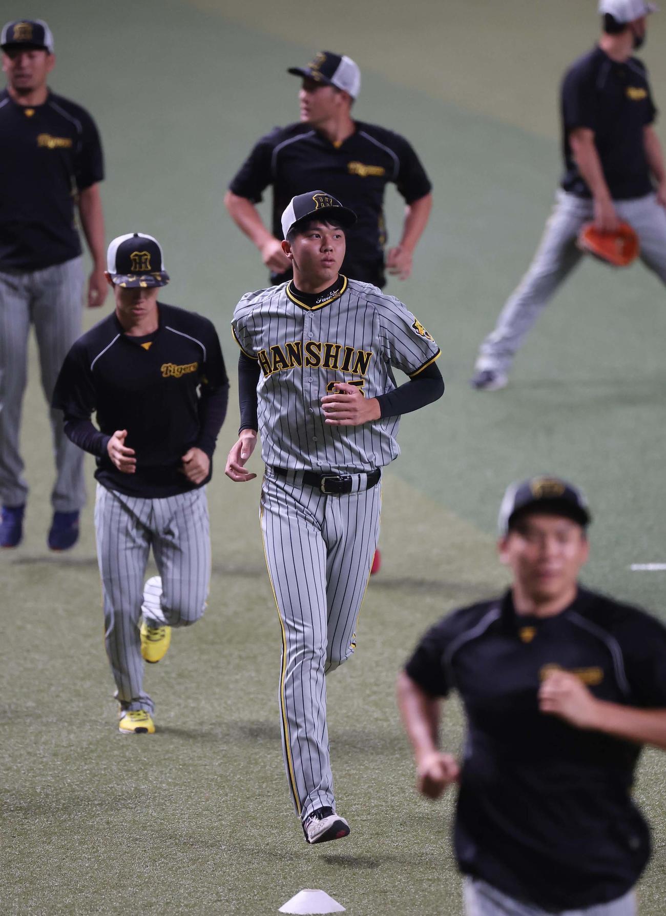 中日対阪神　才木（中央）はランニングをして汗を流す（撮影・上田博志）