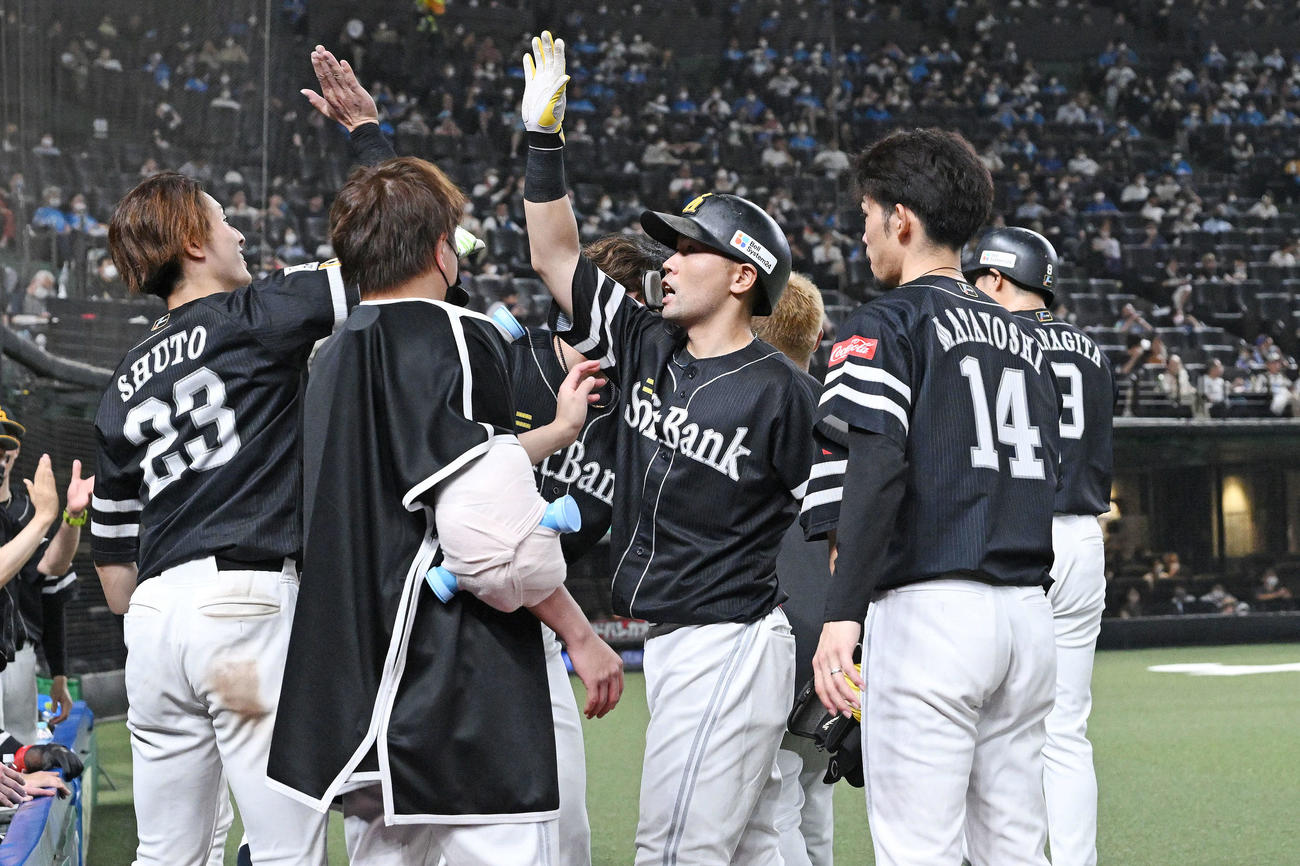 西武対ソフトバンク　9回表ソフトバンク2死二、三塁、2点適時打を放った中村晃（中央）はベンチ前でナインとタッチを交わす（撮影・滝沢徹郎）