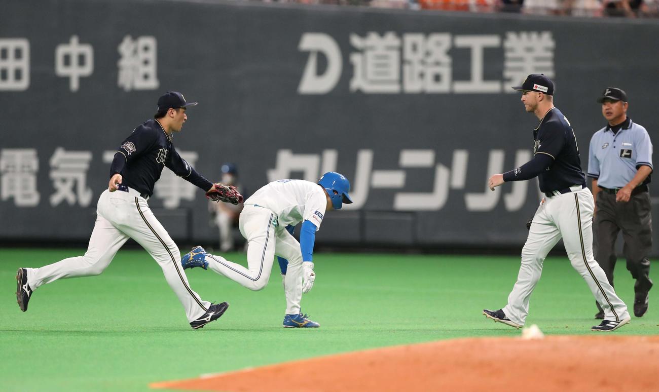 日本ハム対オリックス　3回裏日本ハム2死一、三塁、一塁走者石井が一、二塁間で挟まれる間に三塁走者松本剛が生還（撮影・黒川智章）