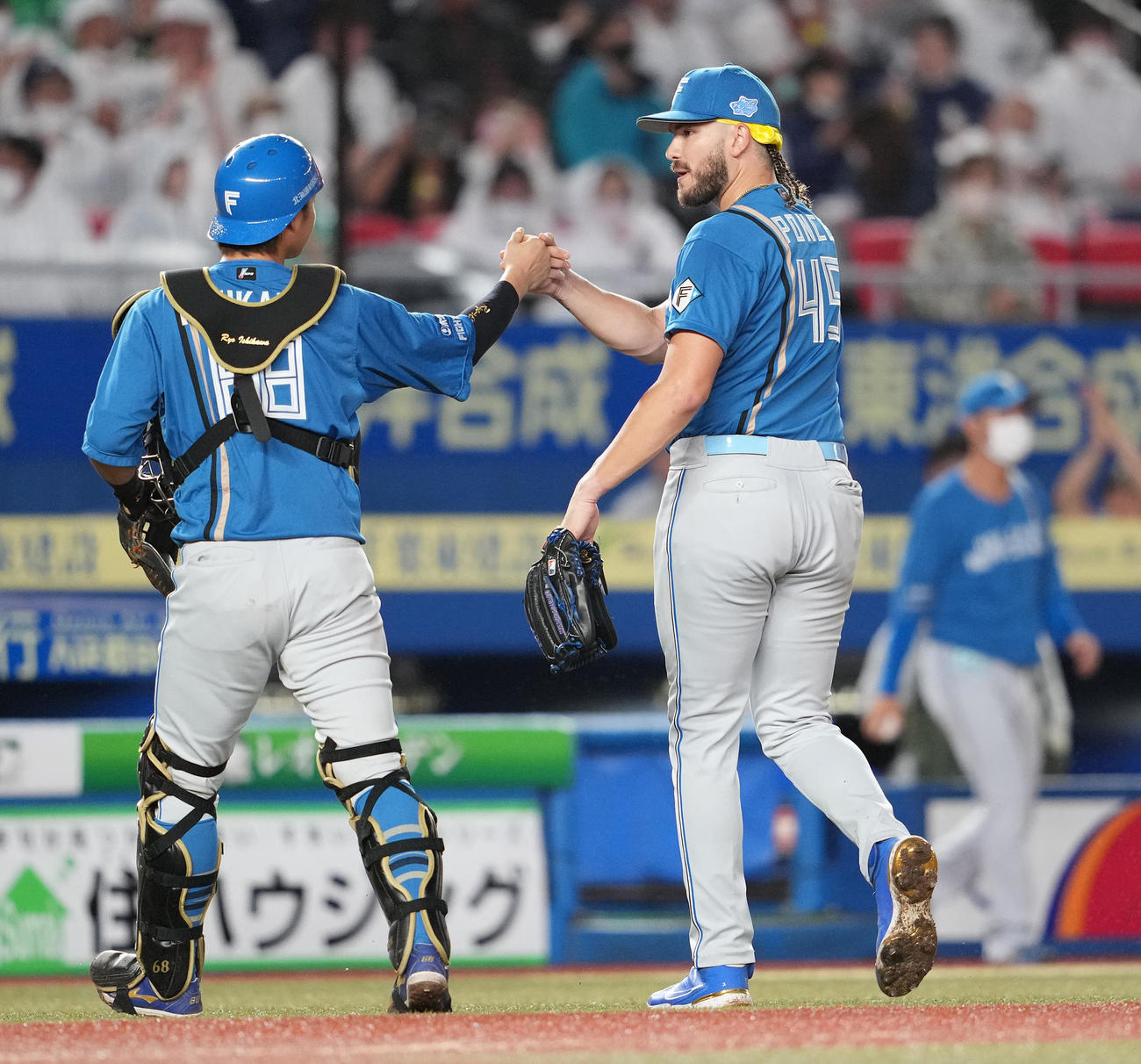 ロッテ対日本ハム　4回裏まで無失点に抑え、石川亮（左）とタッチを交わす日本ハム・ポンセ（撮影・鈴木みどり）
