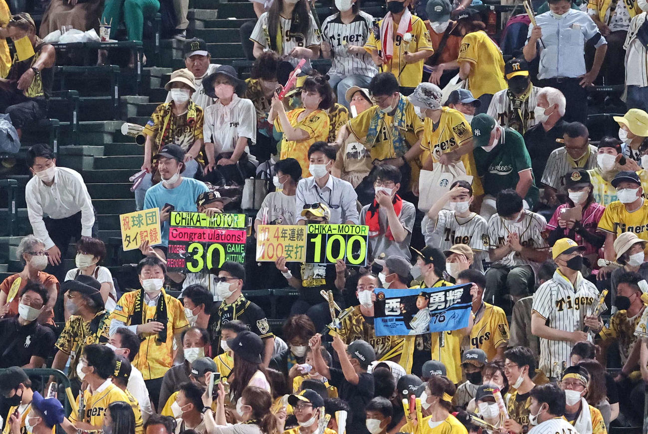 阪神対広島　近本の30試合連続安打と100安打のボードをあげて応援するファン（撮影・上田博志）