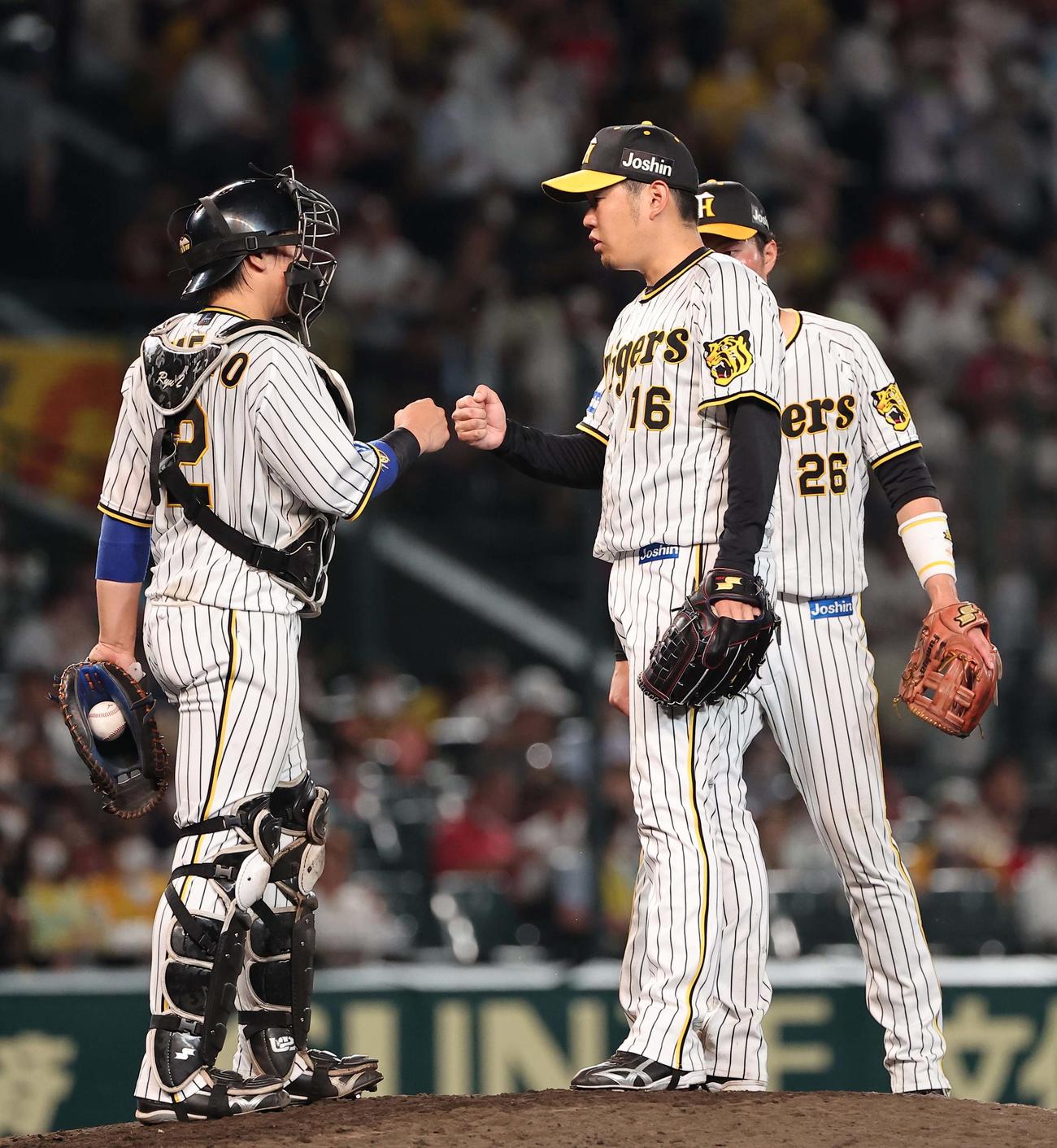 阪神対広島　7回途中で降板となった西勇（中央）は梅野とグータッチする（撮影・上田博志）