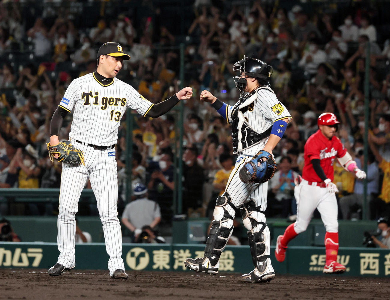 阪神対広島　9回表に登板し無失点で締め梅野（右）とタッチする岩崎（撮影・加藤哉）