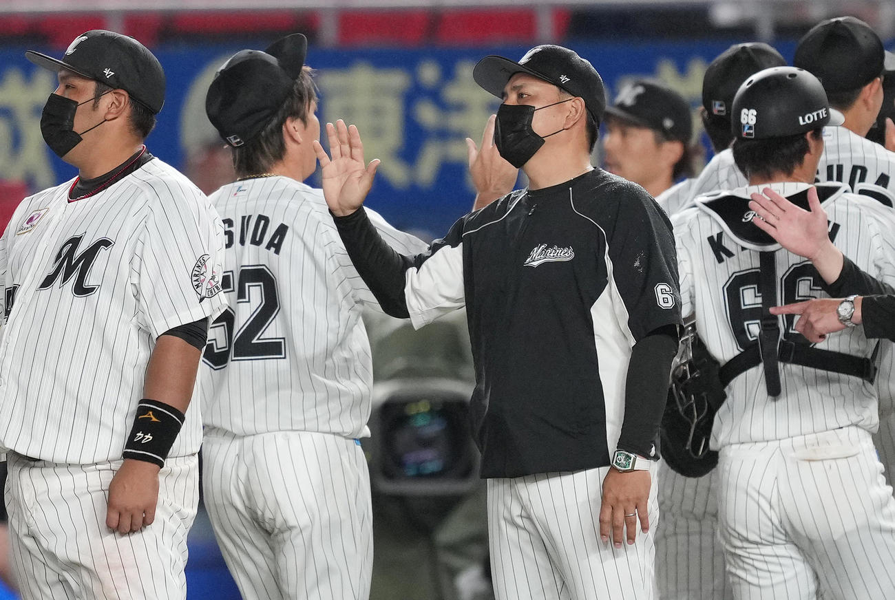 日本ハムに勝利し、最後を締めくくった益田（左から2人目）をタッチで迎える井口監督（中央）。左端は井上（撮影・菅敏