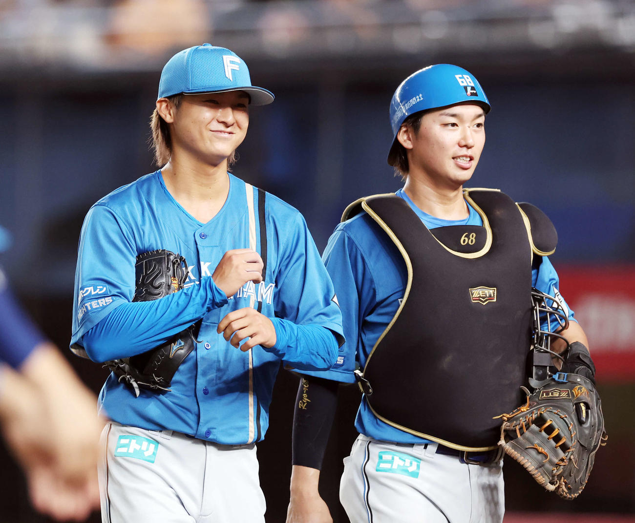 ロッテ対日本ハム　6回裏ロッテの攻撃を抑えた田中（左）は、石川亮と笑顔でベンチに引き揚げる（撮影・浅見桂子）