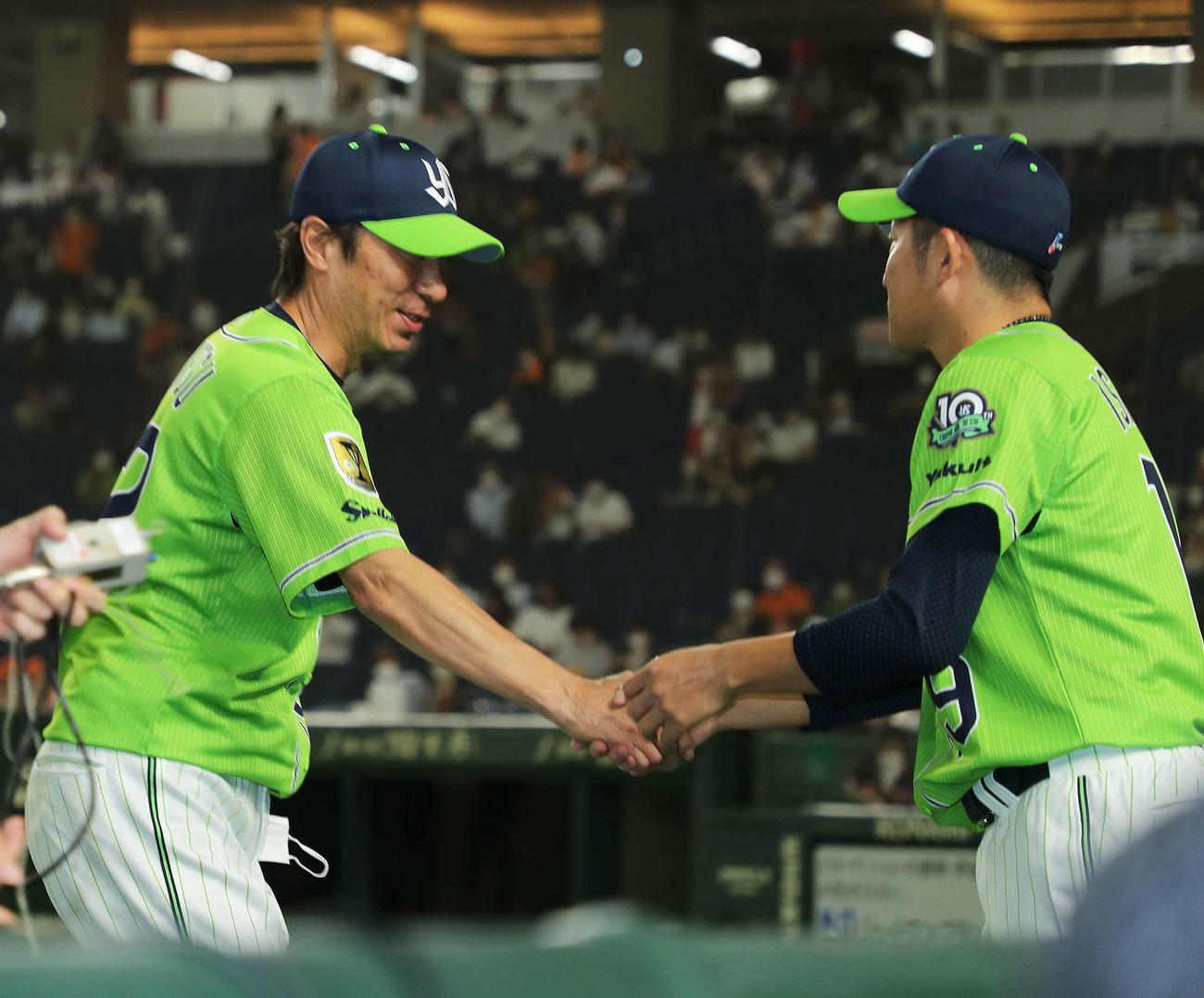 巨人対ヤクルト　巨人に勝利し、インタビューを終えた高津監督（左）と握手を交わす石川（撮影・河田真司）