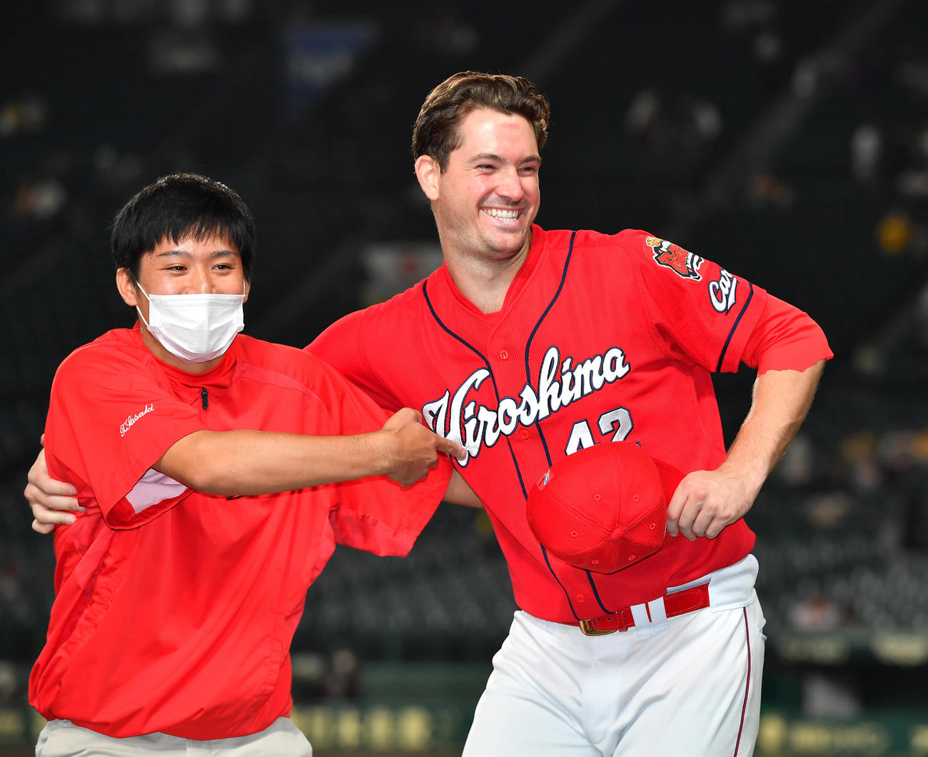 阪神対広島　ヒーローインタビュー後の記念撮影で通訳（左）も一緒にとばかり引っ張り笑顔の広島アンダーソン（撮影・清水貴仁）