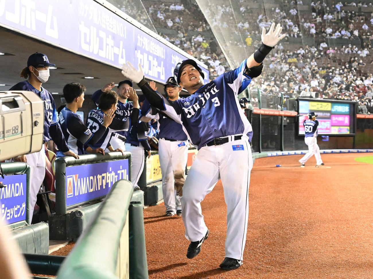 楽天対西武　9回表西武1死二塁、左越え2点本塁打を放った山川（手前）は生還しポーズを決める（撮影・滝沢徹郎）