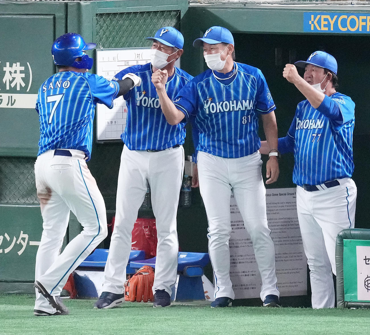 巨人対DeNA 11回表DeNA2死満塁、関根の右2点適時打で生還した二塁走者佐野（左）を笑顔で迎える三浦監督（右から2人目）（撮影・鈴木みどり）